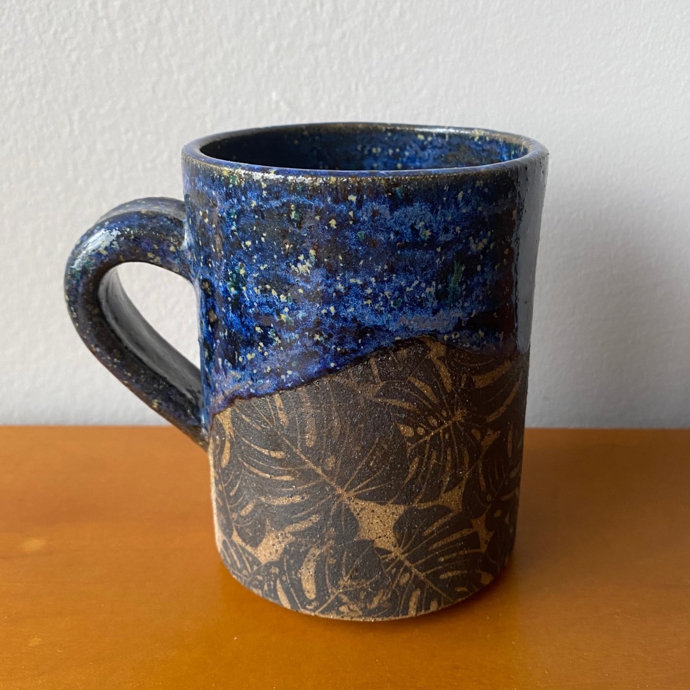 Blue mug with monstera leaf pattern
